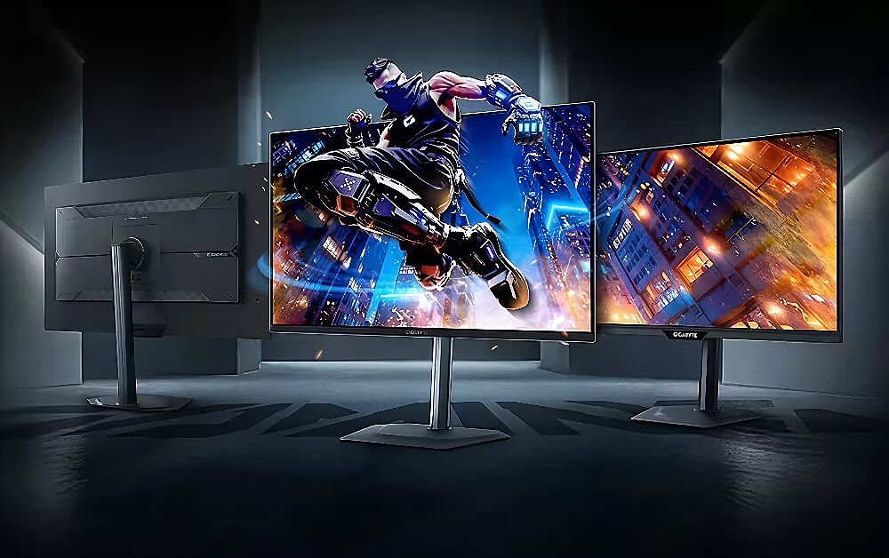 Trois écrans Gigabyte présentés sous différents angles, montrant un écran de face avec un personnage de jeu vidéo et un autre affichant un paysage urbain nocturne.