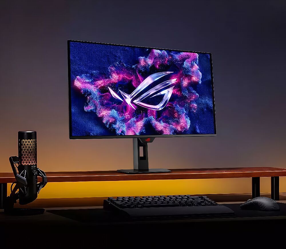 Un écran de PC gamer ASUS affichant un fond d'écran abstrait violet et bleu, posé sur un bureau avec un clavier et une souris noirs.
