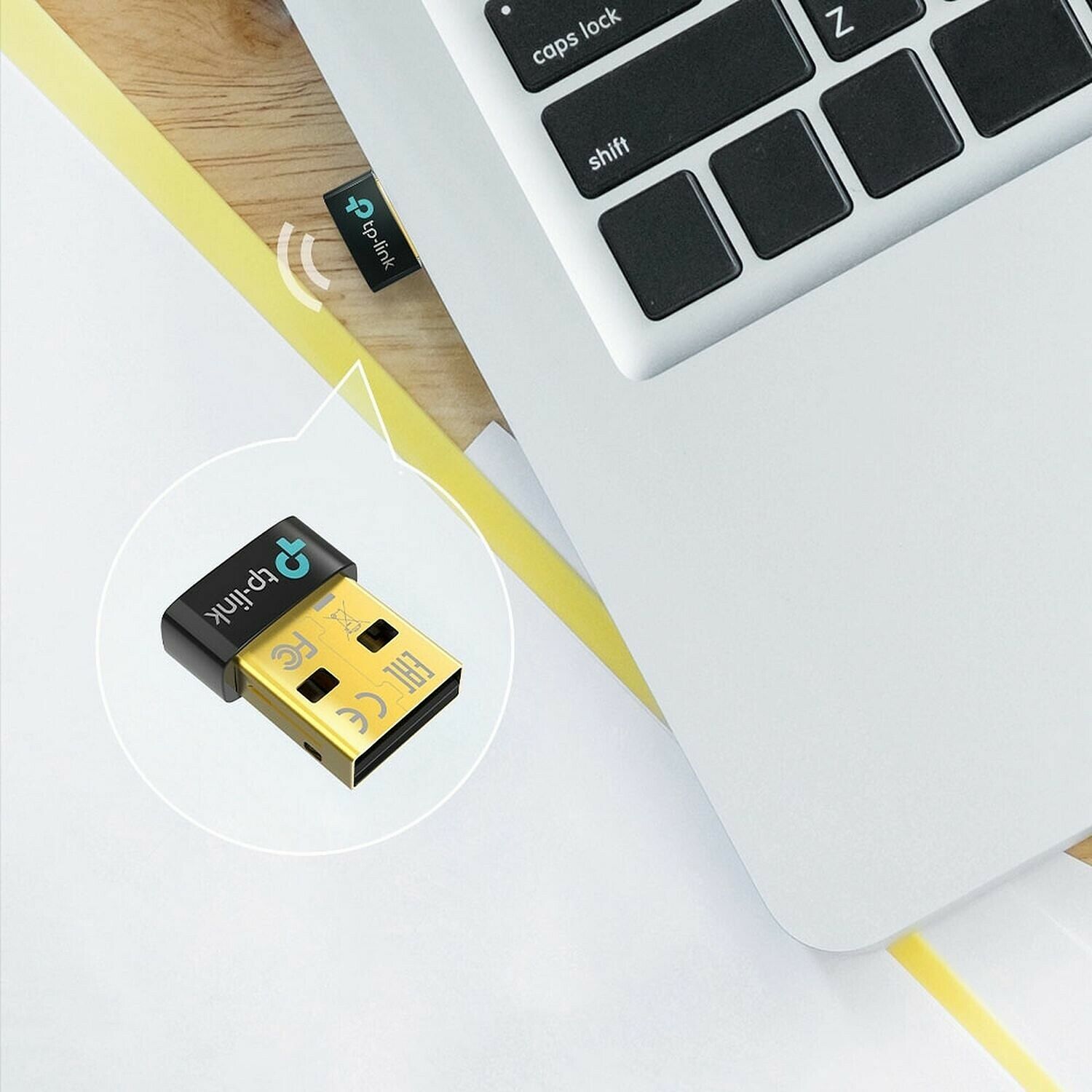 Adaptateur Wi-Fi USB TP-Link compact, présenté à côté d'un ordinateur portable.