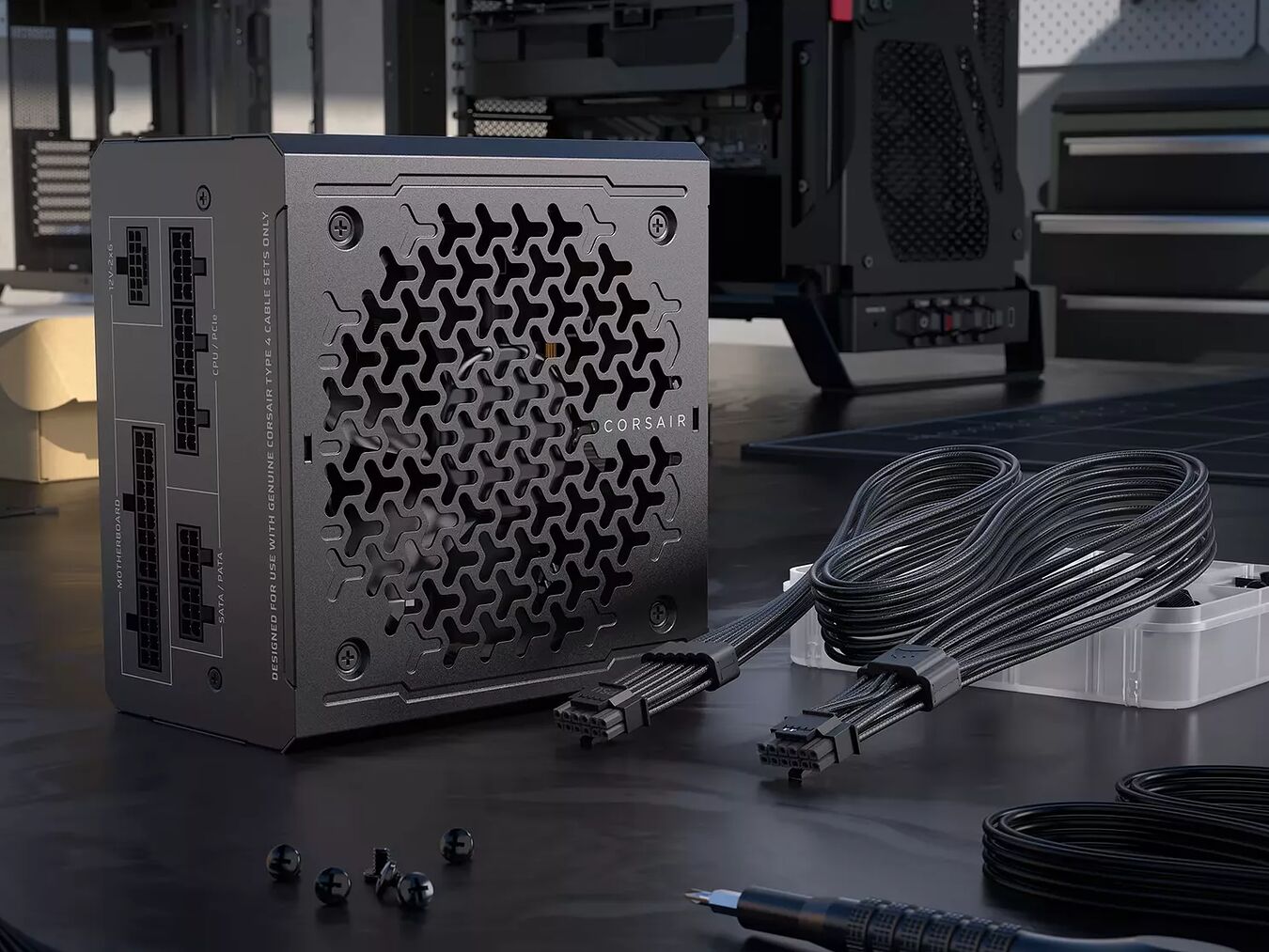 Bloc d'alimentation Corsair noir avec ses câbles modulaires noirs posés sur une table de travail.