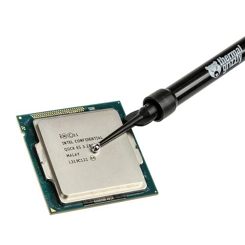 Une main applique de la pâte thermique sur un processeur Intel à l'aide d'un applicateur noir.