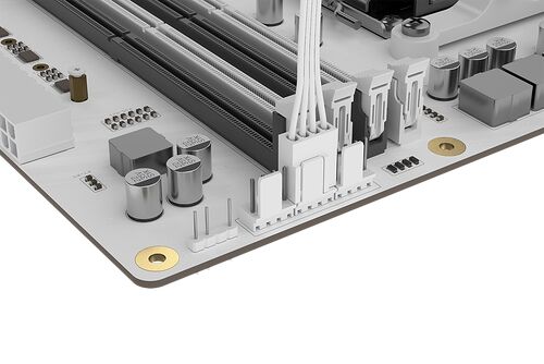 Gros plan sur une carte mère blanche montrant les emplacements de mémoire RAM, les connecteurs de câbles internes et divers composants électroniques comme des condensateurs.