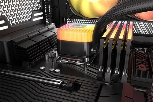 Gros plan sur un système de refroidissement liquide avec un bloc de refroidissement CPU rétroéclairé en dégradé de couleurs, installé sur une carte mère avec des barrettes de mémoire vive à côté.