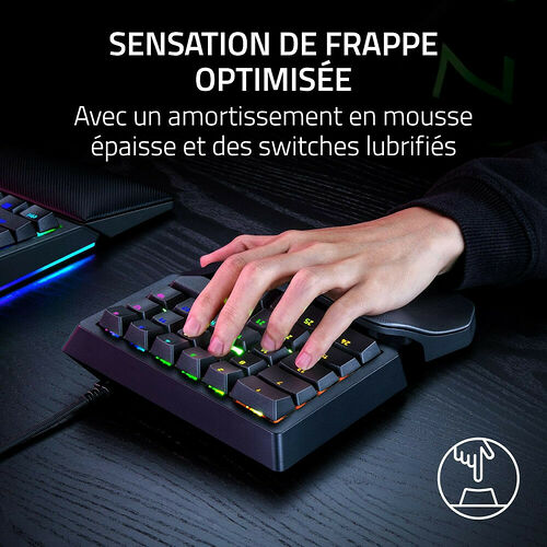Une main tape sur un clavier mécanique compact rétroéclairé, mettant en avant une sensation de frappe optimisée grâce à des switches lubrifiés.