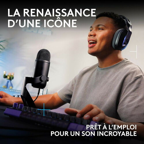 Un homme portant un casque Logitech utilise un microphone noir sur pied et un clavier de contrôle violet pour enregistrer du son.