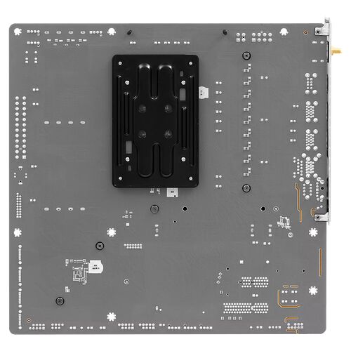 Vue de l'arrière d'une carte mère grise avec ses points de montage et ses circuits apparents.