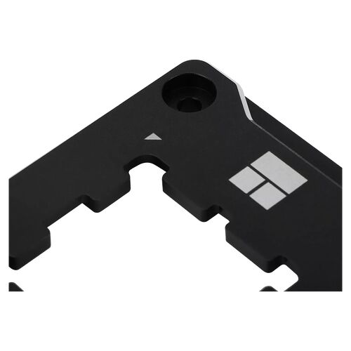 Gros plan sur une pièce métallique noire avec le logo Windows gravé, présentant des encoches de fixation.