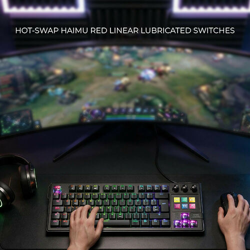 Clavier gaming mécanique avec touches rétroéclairées RGB et switches rouges Haimu, utilisé devant un écran incurvé pour jouer à un jeu de stratégie.