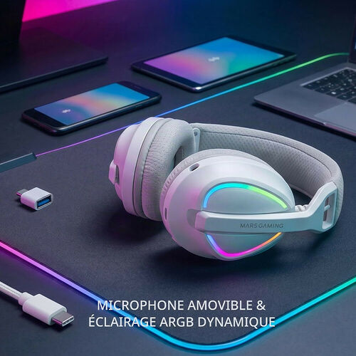 Casque gaming Mars Gaming blanc avec éclairage ARGB dynamique et microphone amovible, posé sur un tapis de souris avec un smartphone et une tablette en arrière-plan.