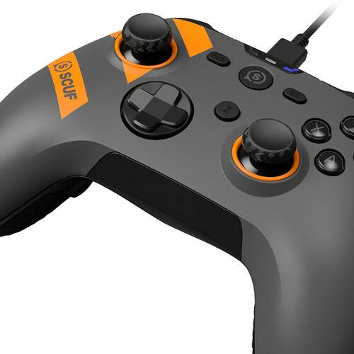 Manette de jeu Scuf grise avec des détails orange et des sticks analogiques noirs.