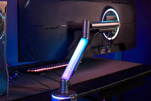 Une barre lumineuse LED fixée à l'arrière d'un écran de PC, diffusant une lumière bleue et violette sur un bureau avec un clavier rétroéclairé.