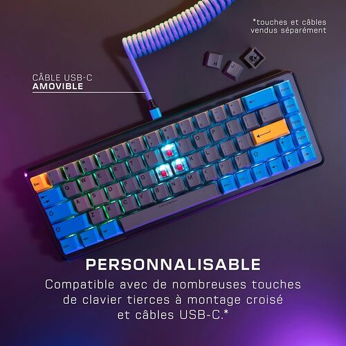 Clavier mécanique compact avec touches bleues et orange, relié par un câble USB-C bleu torsadé. Le clavier est présenté sur un fond sombre avec un éclairage RGB.