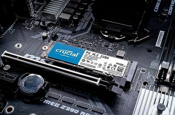 Un SSD Crucial P2 M.2 installé sur une carte mère noire. Le composant est de format 2280 avec une étiquette bleue et blanche.