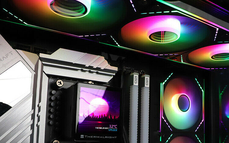 Vue de l'intérieur d'un PC avec un système de refroidissement liquide Thermalright affichant une température de 32°C, accompagné de ventilateurs RGB multicolores et de barrettes de mémoire vive.