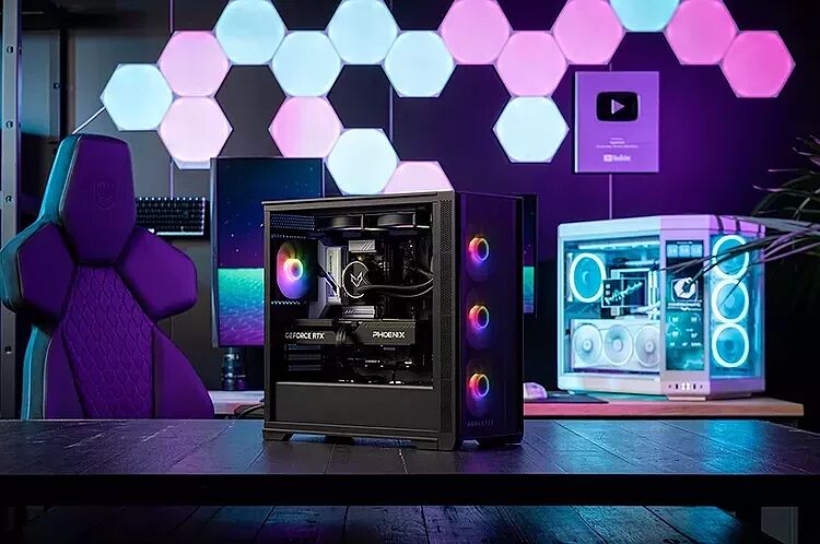 Un PC gamer avec éclairage RGB sur un bureau devant des panneaux lumineux hexagonaux.