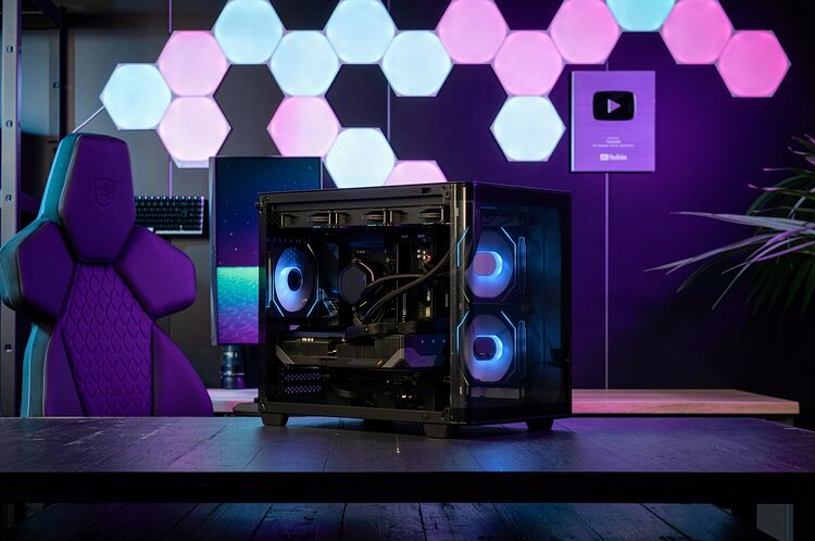 Un PC gamer avec un boîtier vitré montrant des composants éclairés par des LED bleues, posé sur un bureau devant un siège gaming violet et des panneaux lumineux hexagonaux.