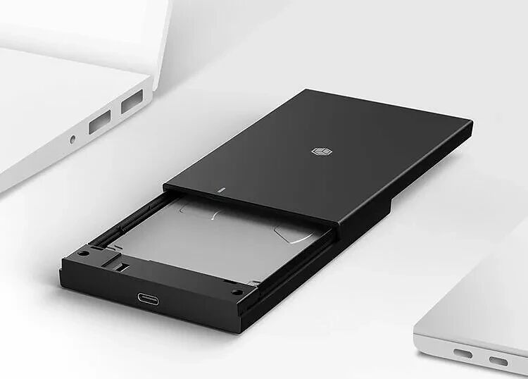 Boîtier externe pour disque dur ou SSD de couleur noire, présenté avec un tiroir ouvert sur un fond blanc épuré.