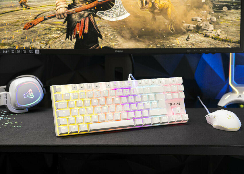 Un clavier mécanique blanc rétroéclairé de la marque G-LAB posé sur un bureau, accompagné d'une souris blanche et d'un casque gamer blanc.