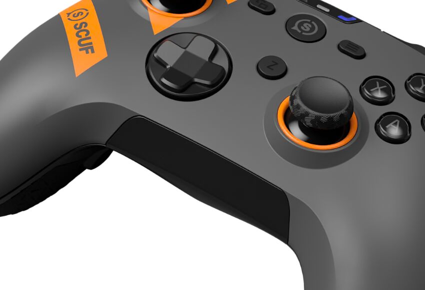 Manette Scuf grise et noire avec des détails orange, montrant le joystick analogique et les boutons de contrôle.