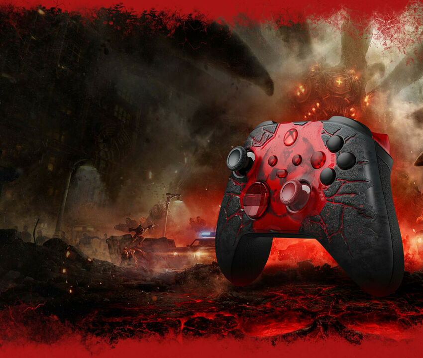 Manette Xbox rouge et noire avec un motif de fissures sur un fond de paysage apocalyptique.
