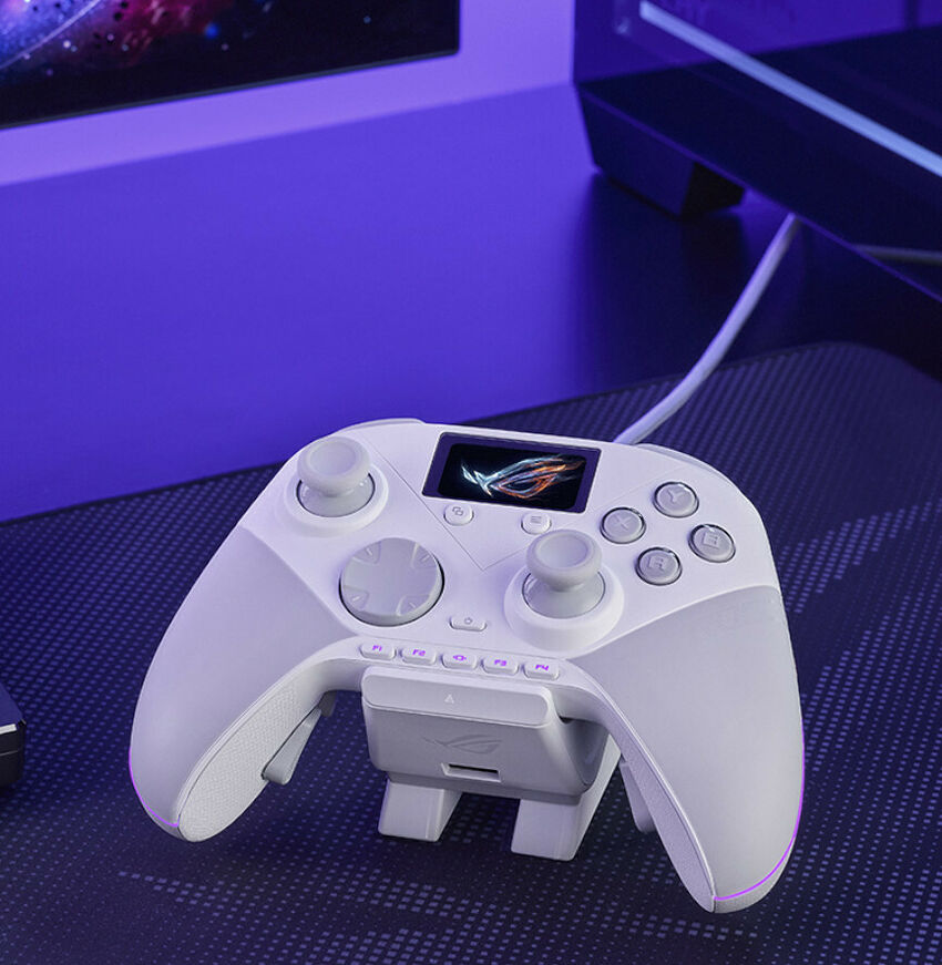 Manette de jeu ASUS blanche avec un petit écran LCD intégré, posée sur un tapis de souris.