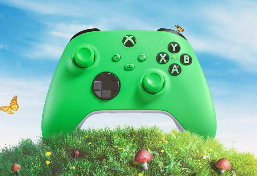 Manette Xbox de couleur verte posée dans l'herbe avec des fleurs et des papillons sous un ciel bleu.