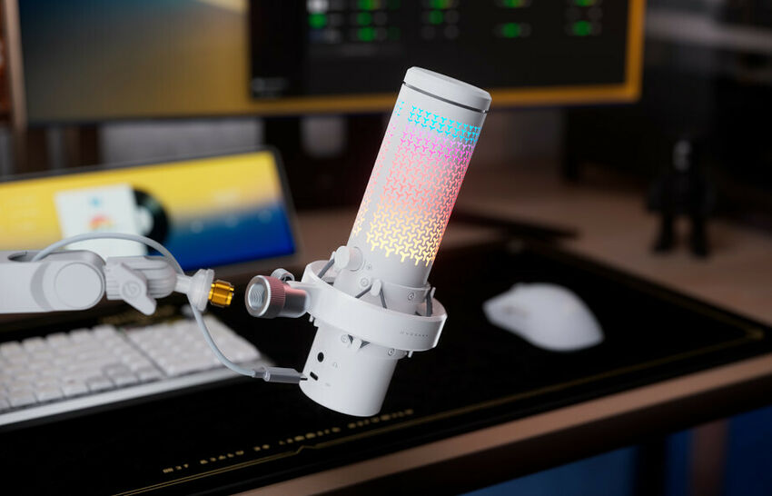 Un microphone Elgato blanc avec un éclairage RGB coloré, monté sur un bras articulé devant un clavier et un écran.
