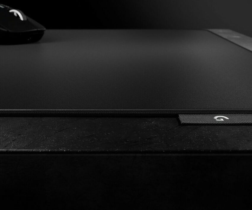 Gros plan sur un tapis de souris Logitech noir avec le logo de la marque visible sur le bord.