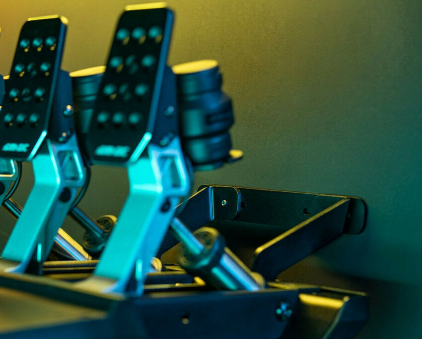 Pédalier de simulation de course avec deux pédales noires et des supports métalliques, éclairé par des lumières bleues et jaunes.