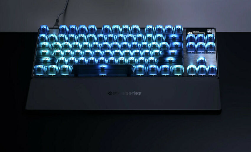 Clavier mécanique SteelSeries avec rétroéclairage bleu, présenté sur un bureau sombre.
