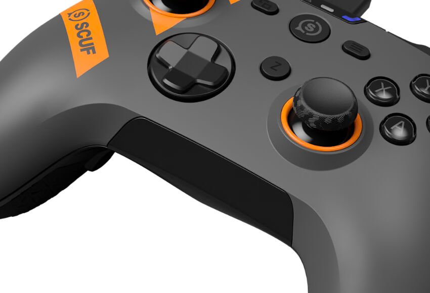 Manette de jeu Scuf grise et noire avec des détails orange, montrant le joystick analogique et les boutons de contrôle.