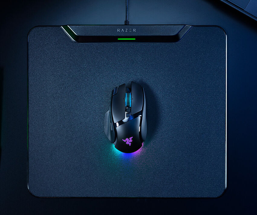 Une souris Razer avec éclairage RGB posée sur un tapis de souris Razer noir.